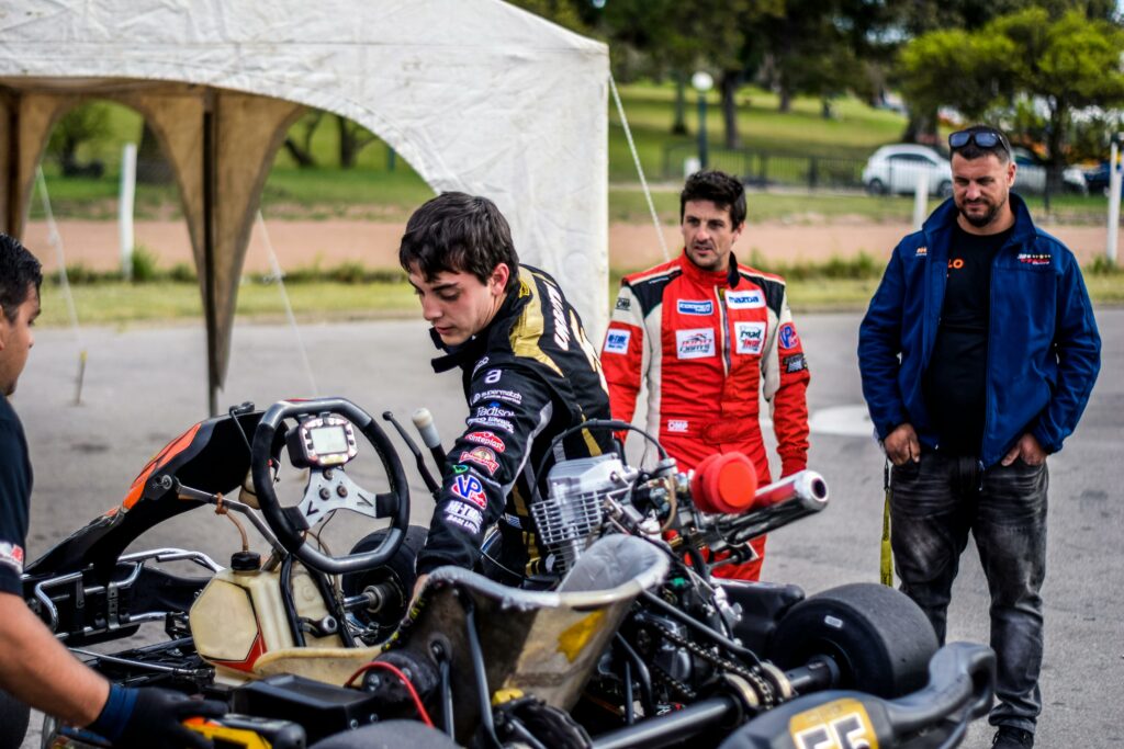 Team preparing go-kart for an outdoor race, showcasing teamwork and motorsport passion.