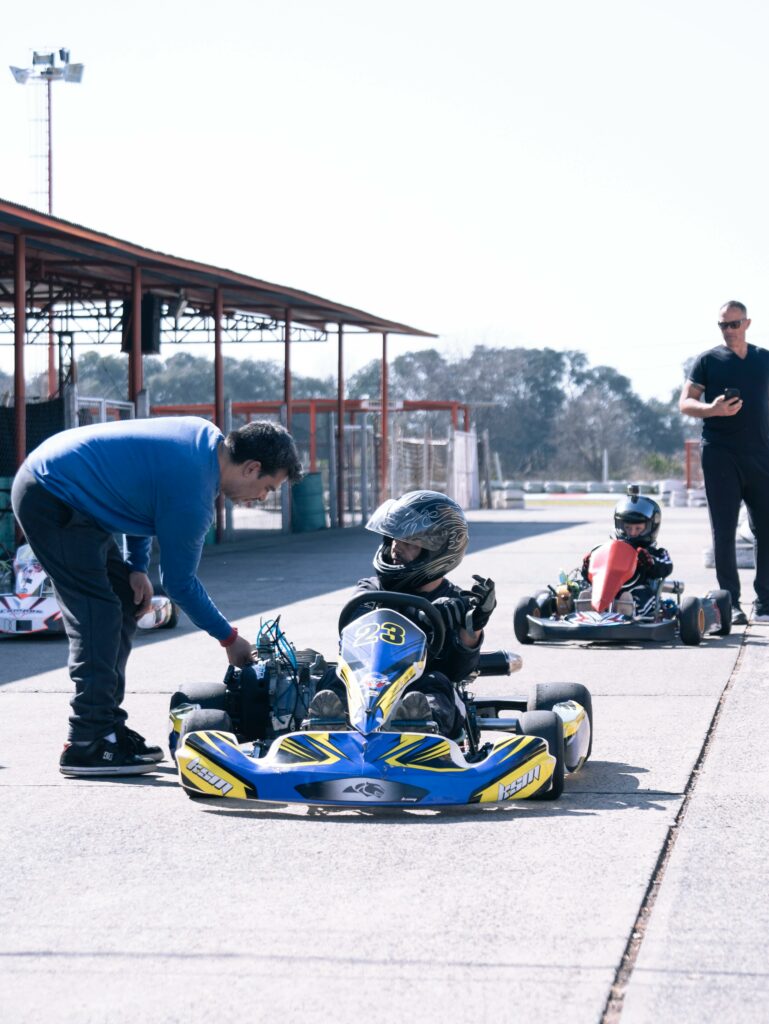 Go-karting at a lively outdoor race track with participants gearing up for a thrilling competition.